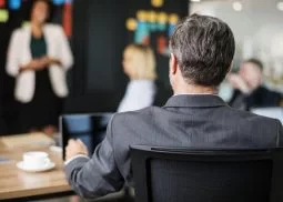 Zdjęcie przedstawia osobę prezentującą przed niewielką grupą